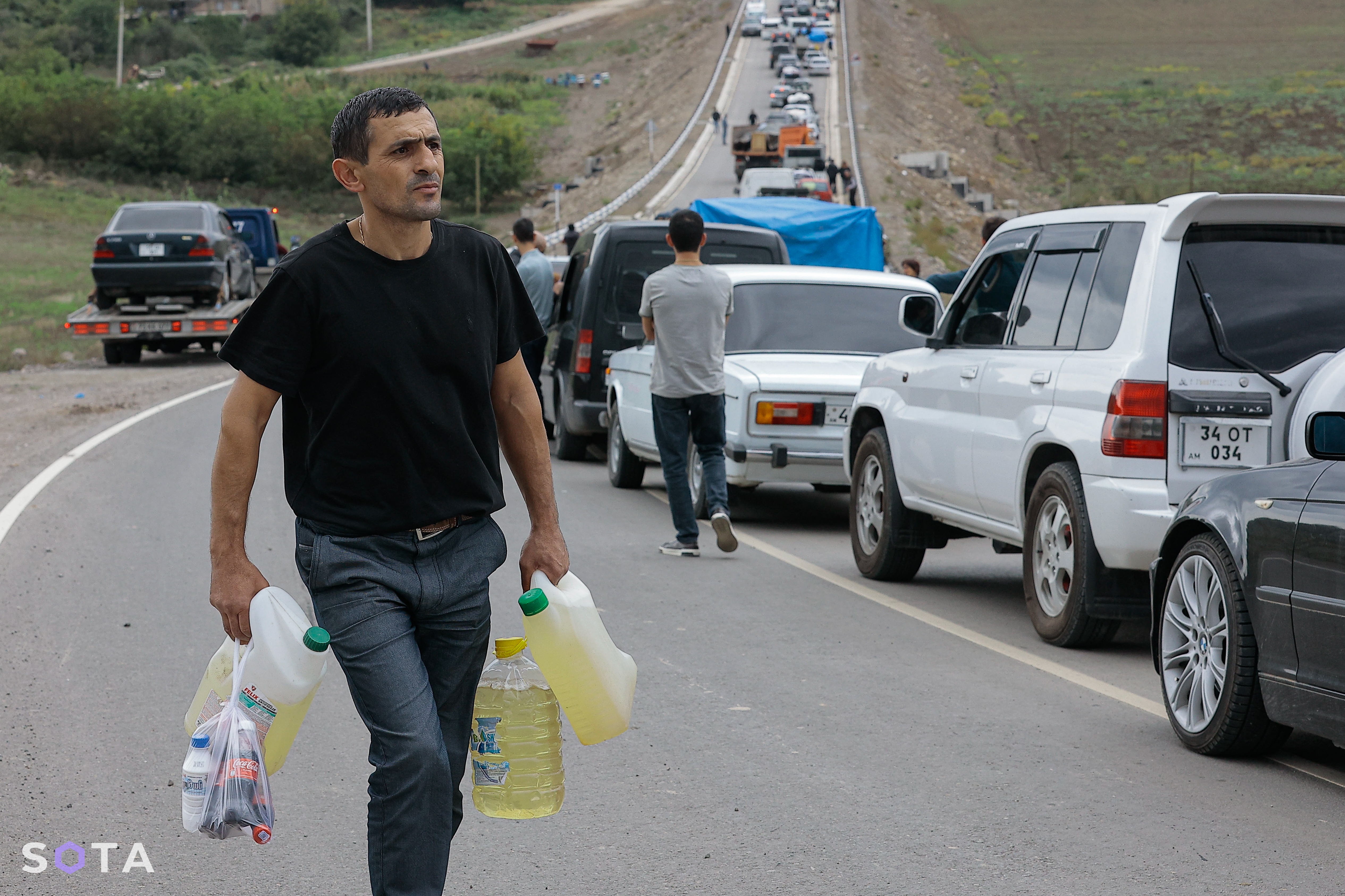 Эвакуация жителей Нагорного Карабаха после прихода войск Азербайджана.&nbsp;Беженец несет бензин для своего автомобиля возле первого гуманитарного лагеря после Лачинского коридора, в селе Корнидзор.
Василий Крестьянинов / SOTA